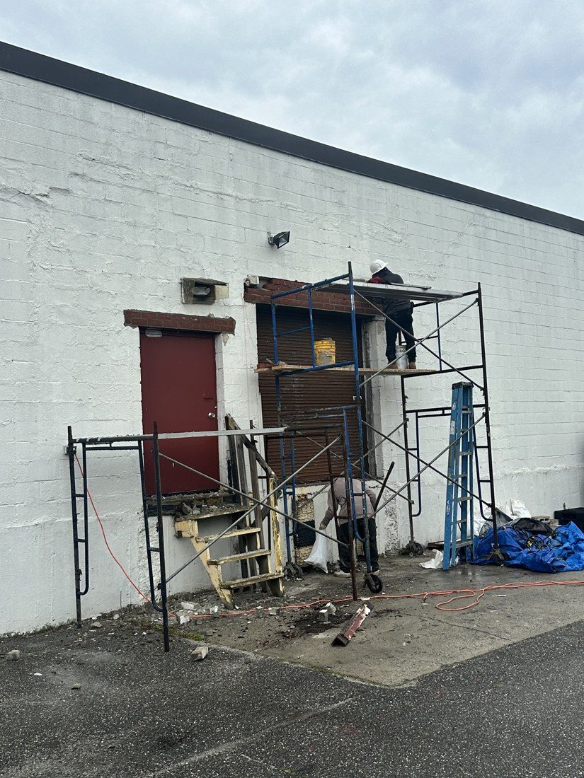 Emergency exit opening with masonry removed and shoring set at an operating warehouse