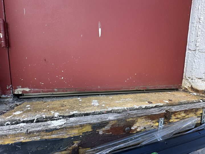 Rotted threshold at an exit door before repair.