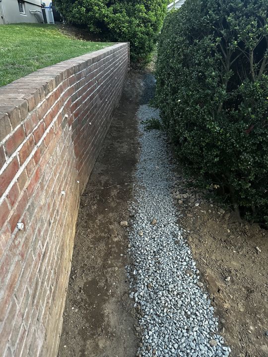 Gravel drain channel along the garden wall.