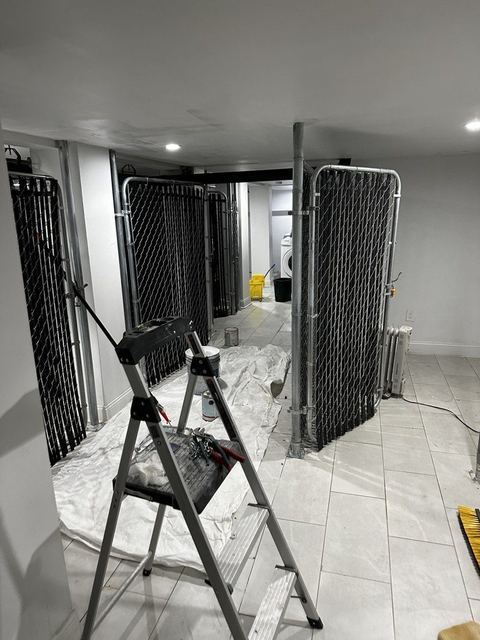 Completed chain-link tenant storage enclosures in a Brooklyn multifamily building